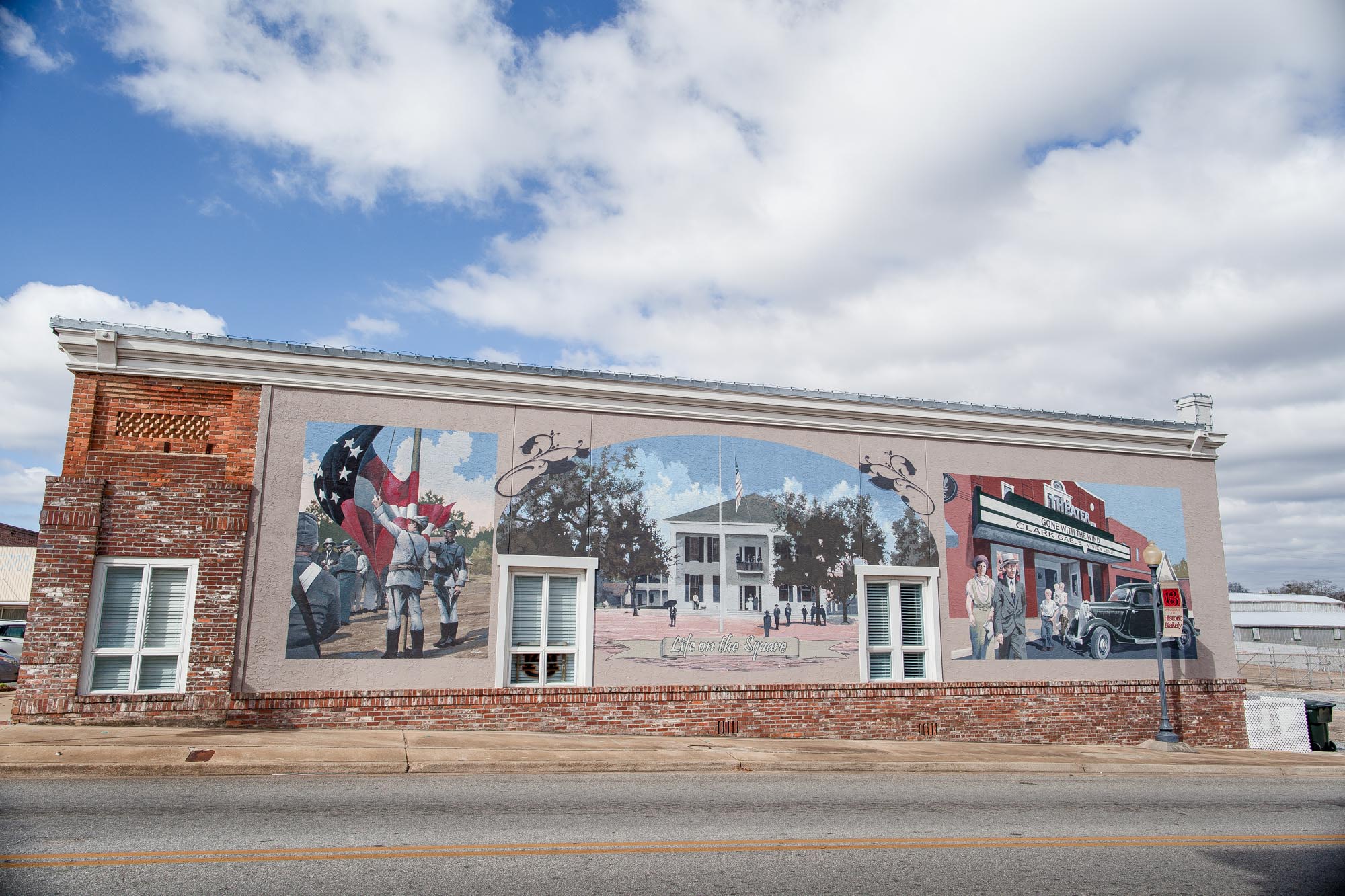 Muralist, Wes Hardin depicts days gone by on the Courthouse Square on the right corner as you approach from the north side of the square.